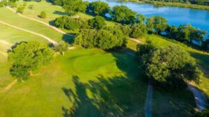 Aerial view of fairway and green with river in the background