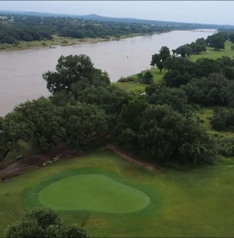 Aerial view of green with river in the background